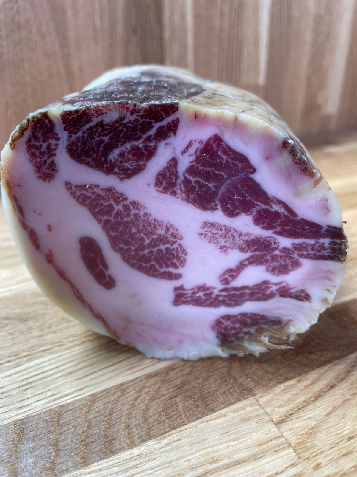 A whole coppa cut open, showing its marbling