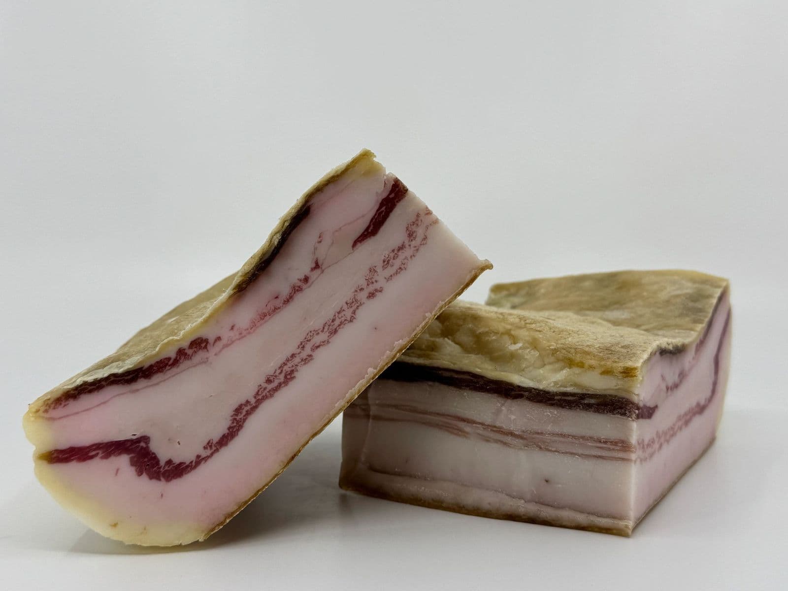 Two pieces of cured pancetta